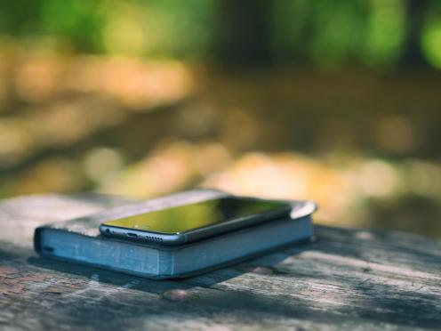 Un téléphone portable noir posé sur un livre