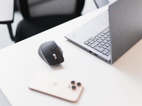 Smartphone à côté d’un ordinateur portable ouvert et d’une souris.