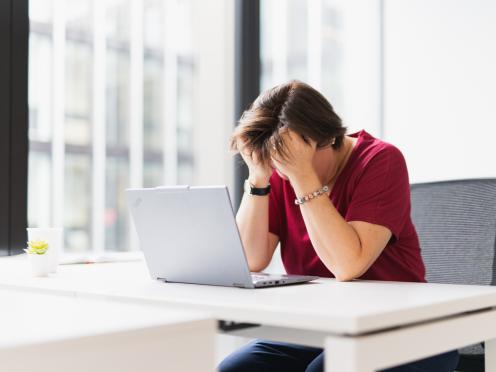 Personne la tête dans les mains à son bureau