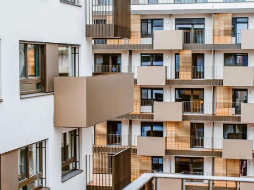Bâtiments blancs avec balcons bruns.