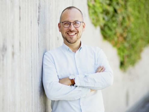Julien Loichat im Freien, lächelnd, mit verschränkten Armen.