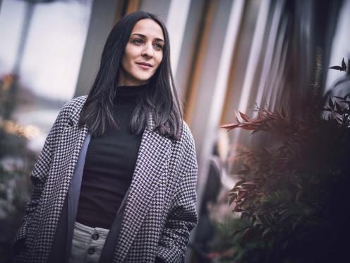 Portrait de Nabila Bouzouina marchant à l’extérieur.
