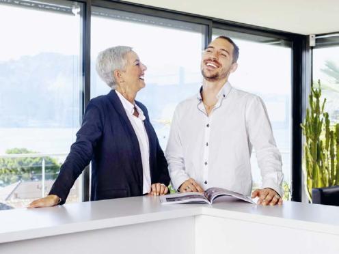 Deux personnes discutent devant un magazine ouvert.