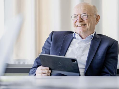 Vincent Ducrot sitzt und hält ein Tablet in einer Hand.