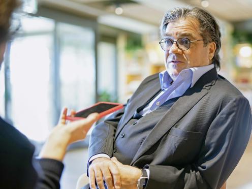 Ritratto di Antoine Hubert seduto mentre parla in un ambiente interno.