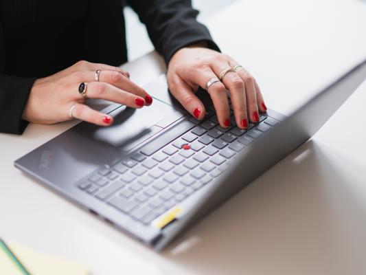 Mains tapant sur un ordinateur portable.