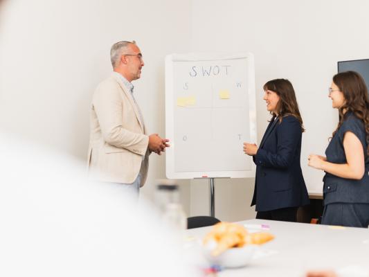 Drei Personen vor einem Flipchart