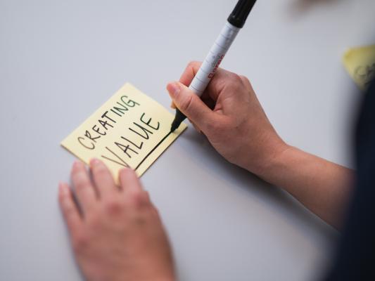 Die Wörter «Creating value» auf einem gelben Post-it