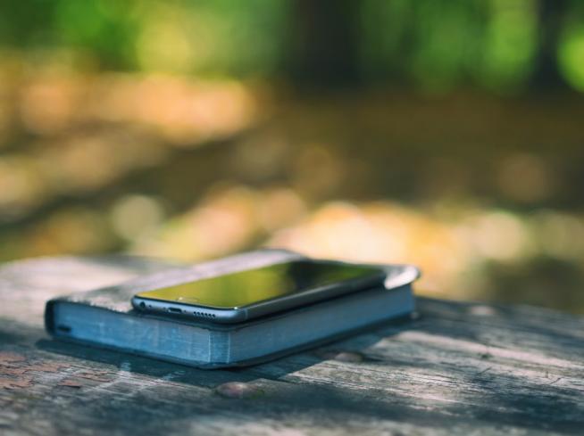 Un téléphone portable noir posé sur un livre